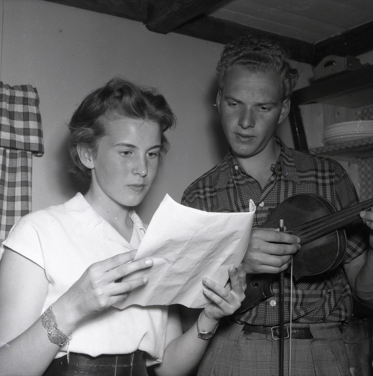 En kvinna och en man läser ett papper vid IOGT-NTO:s stuga på Hårgaberget den 4 augusti 1954.