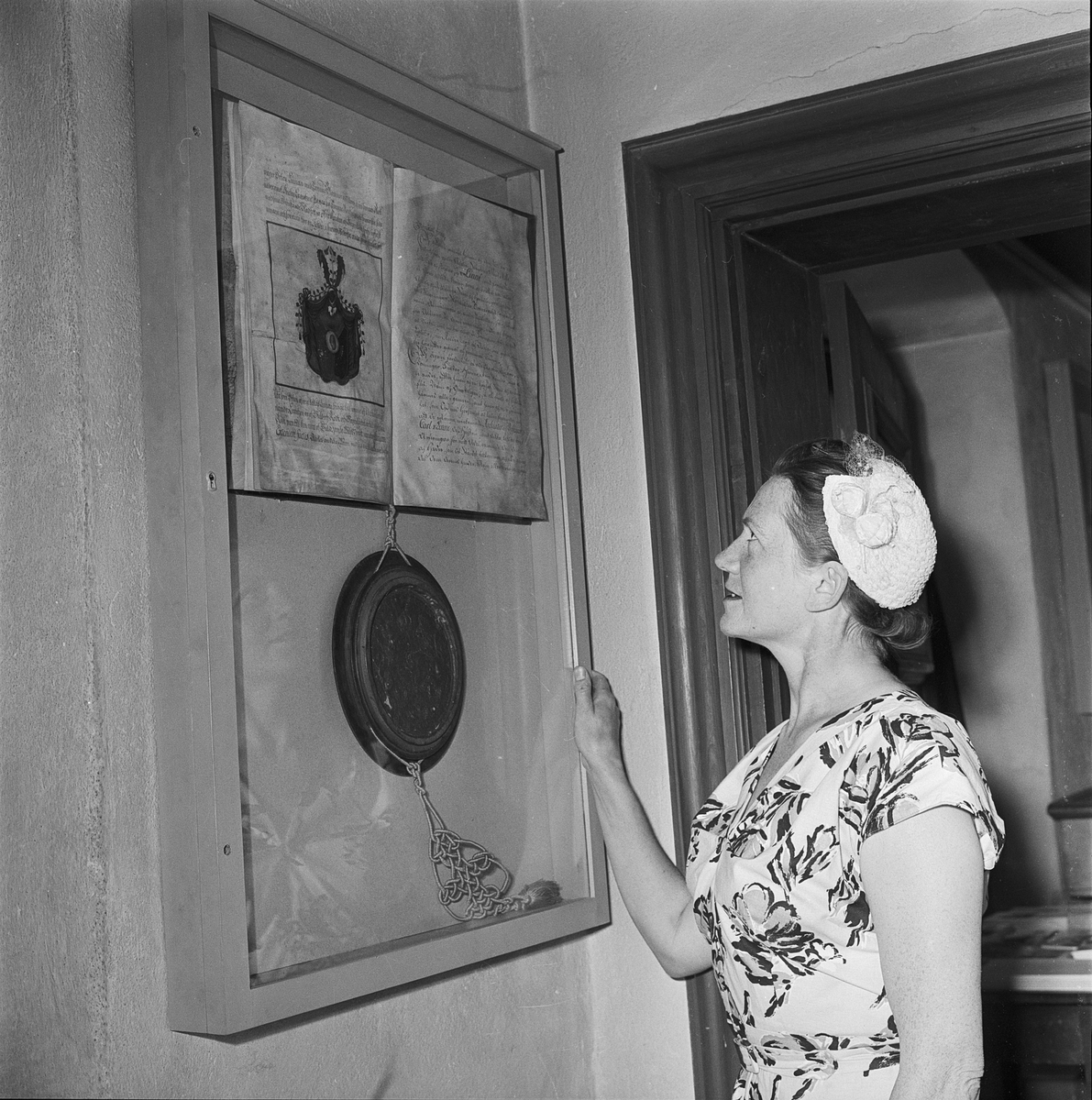 Kvinna vid minnestavla, Linnémuseet, Uppsala 1956