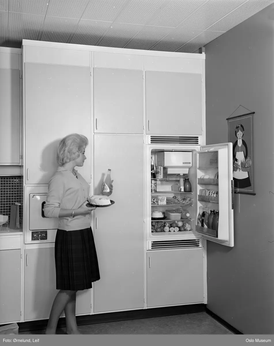Nordia kjøkken, innebygget Electrolux kjøleskap, åpent, matvarer, kvinne, marsipankake, Solo brusflaske, tekstilbilde på veggen