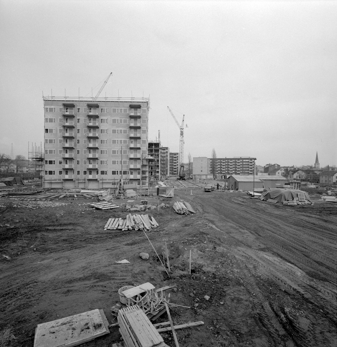 Mars månad 1973 och bebyggelsen i västra delen av Gamla stan i Motala är under förändring. Bilden visar de blivande punkthusen utmed Drottninggatan under uppförande.
