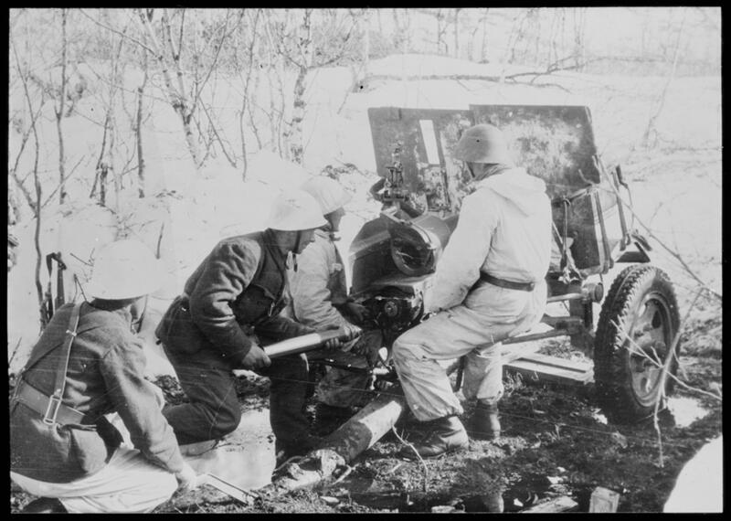 Foto: Kari Berggrav, Norsk artilleristilling ved Narvikfronten i mai 1940. NTBs Krigsarkiv i Riksarkivet. Soldater samlet rundt en kanon.