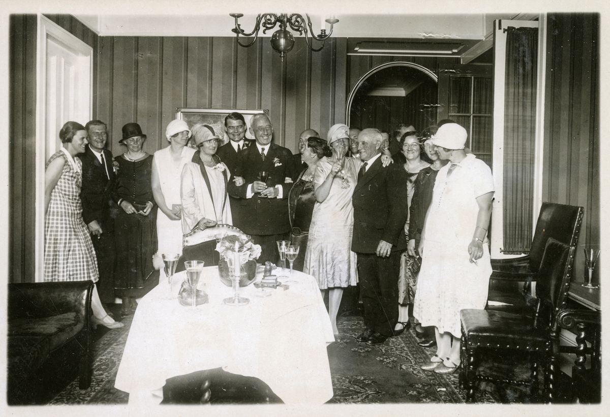 Middagsarrangement for Roald Amundsens og hans følge. Roald Amundsen oppstilt sammen med gjester bak bord med vinglass - Roald Amundsens ankomst til Bergen med S/S "Bergensfjord" efter "Norge"s flukt overe Polen. - 12. juli 1926