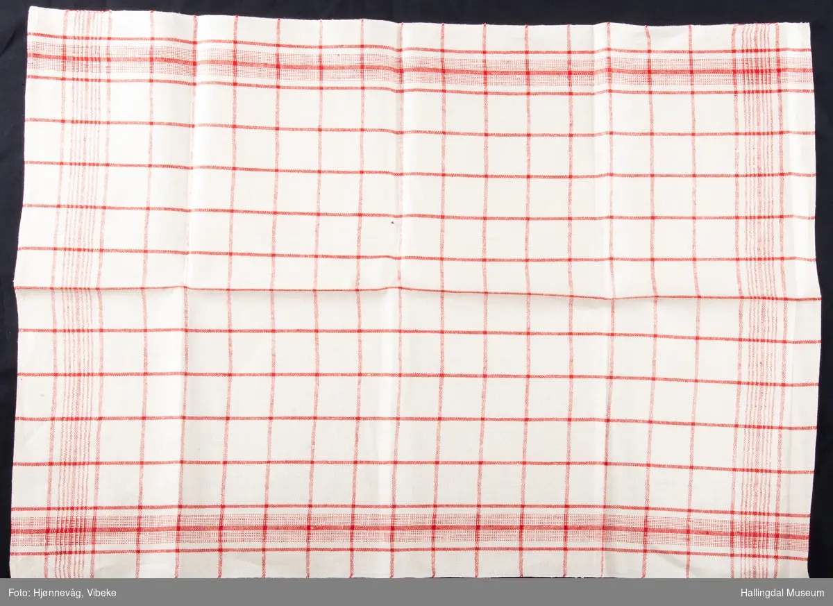 Glasshåndkle i lin med hvit og rød renning. Innslag med hvitt og rødt garn. Hvit bunn med røde ruter.