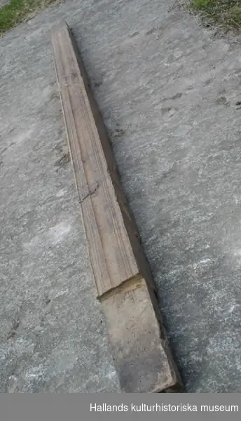Delar till vävstol. Trä, smidda detaljer. a) Trä, metall, snidad, smidda detaljer, kugghjul i ena änden. Spännhandtag. Diameter: 28 cm, längd: 129 cm.
 b) Trä, snidad. Bredd: 10 cm, längd: 57 cm, höjd: 6 cm. 
c) Trä, snidad. Diameter: 7 cm, längd: 139 cm. 
d) Trä, snidad, profilsågad. Bredd: 7 cm, längd: 155 cm, höjd: 6 cm.
 e) Trä, snidad, den del tramorna är fästade vid. Hål för f) och vid mitten även hål i bägge ändar. Bredd: 7 cm, längd: 133 cm, höjd: 6 cm. 
f) Plugg med hål. Trä, snidad, sitter i e), samma som g). Bredd: 5 cm, längd: 18 cm, höjd: 2 cm.
g) Plugg med hål. Trä, snidad, sitter i e), samma som f). Bredd: 5 cm, längd 18 cm, höjd: 2 cm. 
h )Trä, snidad. Bredd: 5 cm, längd: 143 cm, höjd: 3 cm.
i) Trä, snidad, samma typ av föremål som b), samma funktion. Bredd: 10 cm, längd: 56 cm, höjd: 5 cm. 
j) Trä, snidad. Sittbräda till vävstol, kvadratiska hål vid kortsidorna. Bredd: 24 cm, längd: 142 cm, höjd: 2 cm. 
k) Trä, snidad, borrade hål i ena änden, den del varpen viras upp från. Diameter: 21 cm, längd: 156 cm. 
l) Trä, snidad, profilsågad, hål i bägge ändar. Bredd: 7 cm, längd: 146 cm, höjd: 3 cm.
m) Trä, snidad, sidostycke till vävstol. Bredd: 7 cm, längd: 163 cm, höjd: 143 cm. 
n) Trä, snidad, sidostycke till vävstol. Bredd: 7 cm, längd: 162 cm, höjd: 142 cm.
 o) Trä, snidad. Slagbom till vävstol. Vissa delar ersatta med nyare. Bredd: 4 cm, längd: 137 cm, höjd: 75 cm.
 p) Trä, snidad. Nytillverkad del till vävstol som ersatt en äldre. Diameter: 3 cm, längd: 147 cm.