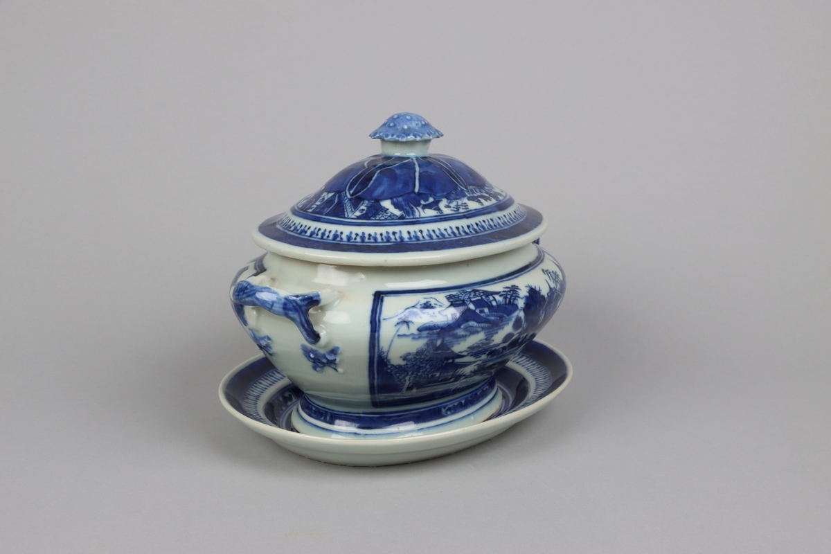 Oval shaped lid with slightly domed form, on top a knob in shape of a flower head. Around the knob lotus leaves, surrounded by a list of pagoda landscapes. The edge of the lid with dark blue border in a criss cross pattern. Oval lobed bowl with angular handles, supported on a central fot. On both sides of the bowl decor of landscape scenes of pagodas, buildings, gardens and waters. Handles in shape of bent tree branches. On the foot a dark blue border with rectangular reserves filled with symbols of good fortune. Oval stand with a lip decorated with dark blue border with criss cross patterns and chrystanthemum flowers. The everted rim is decorated with a dark blue border with a similar pattern as above, but complemented  with oval reserves filled with symbols of fortunes. The well is decorated with landscapes scenes of pagodas, buildings, gardens and bridges. All decor in blue underglaze.