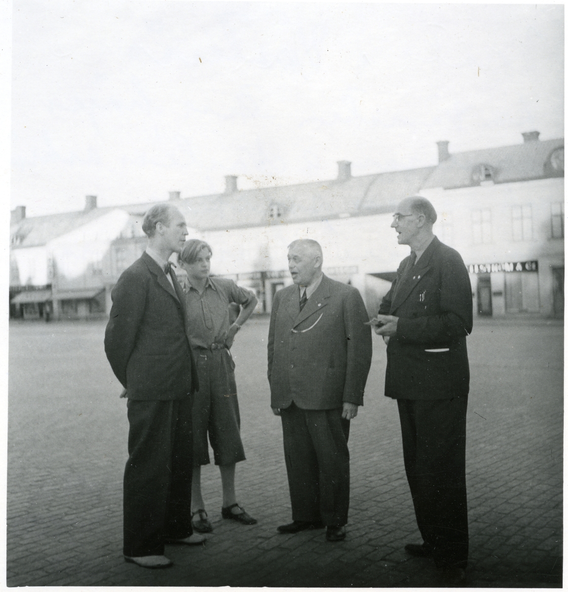Västerås, Stora torget.
Tre män och en pojke stående på torget.