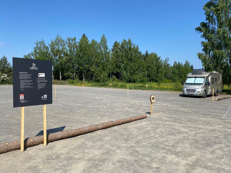 En bobil står parkert på bobilparkeringen til Norsk skogmuseum. Parkeringen er gruslagt.