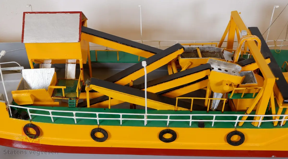 Miniatyr båt/slepe-lekter med påbygd komplett grustak. Bygget i hovedsak av tynn kryssfiner.