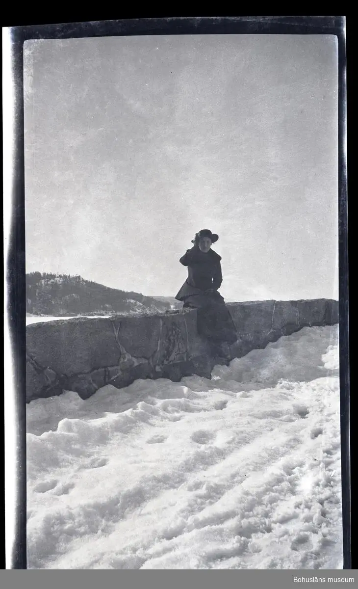 En person sittandes på en stenmur.