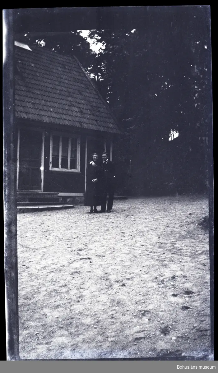 Två personer ståendes framför ett hus.