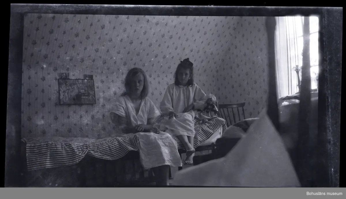Två barn sittandes i en säng.