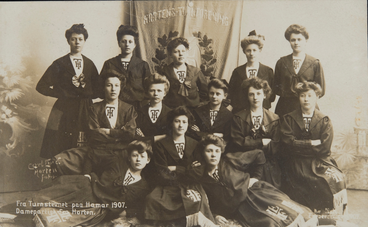 Postkort, Hamar, Det nasjonale turnstevnet på Hamar i 1907, stor gruppe 13 turnere fra Horten Turnforening, turndrakter, fane, Dameturnere,