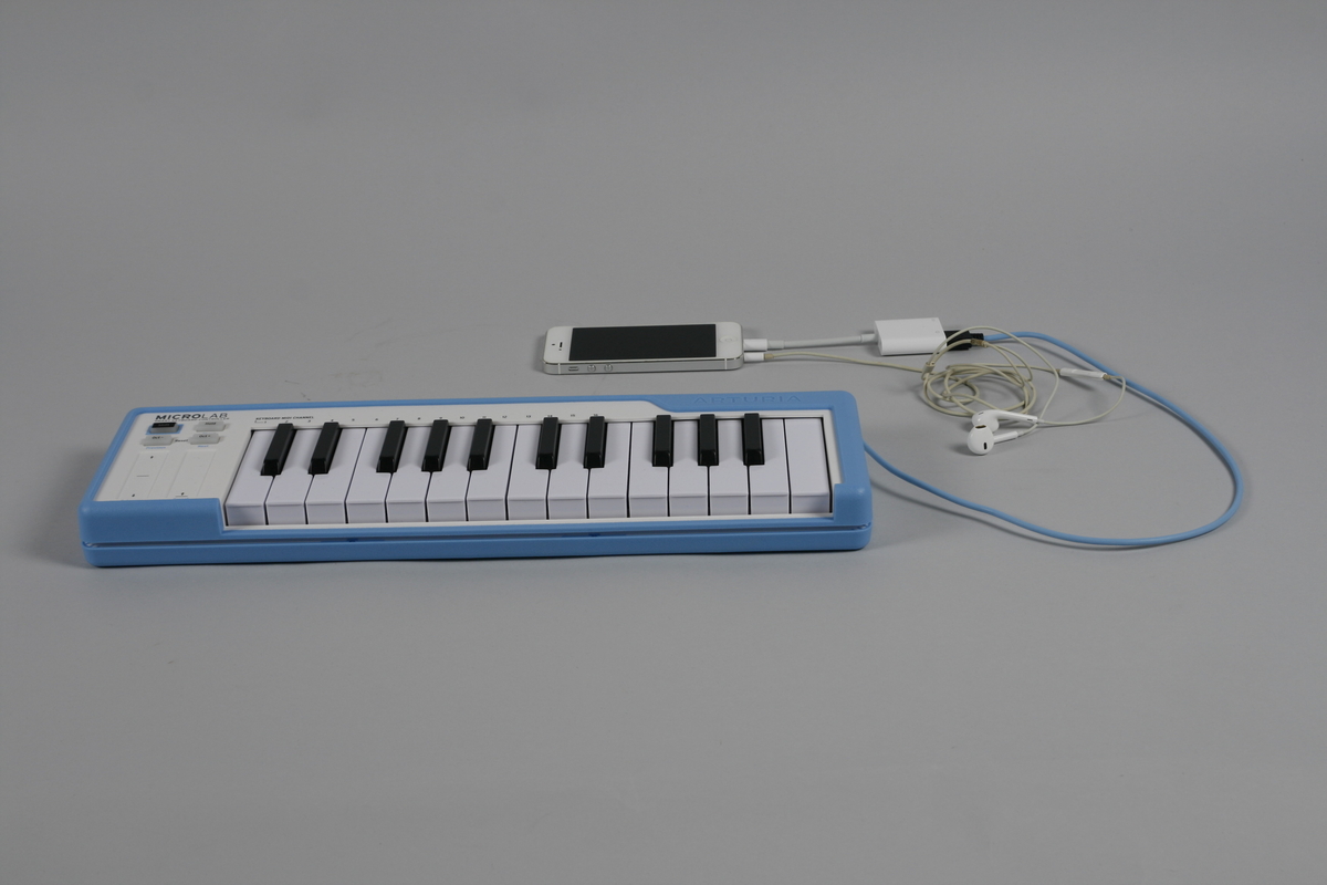 Lite digitalt keyboard med 25 taster. På venstre side for tastaturet to striper for justering samt fire knapper. USB-kabel som kan vikles rundt og festes i kanten av instrumentet. 