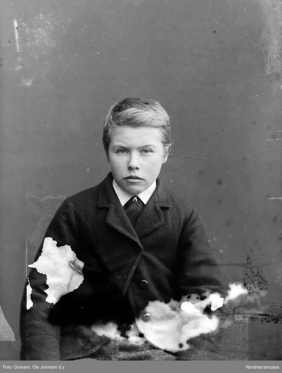 Portrett av gutt i halvfigur med dress.