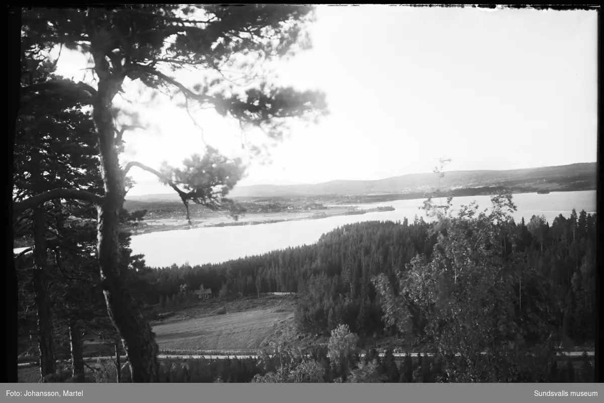 Vy fotograferad från Borgaråsens topp över Marmen mot Attmarby. Det lilla torpet i skogsbrynet är troligen fastigheten Skedvik 4:11.