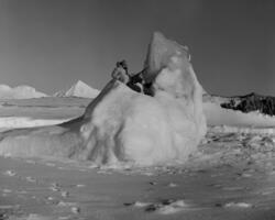 Mann med våpen sitter på isfjell.