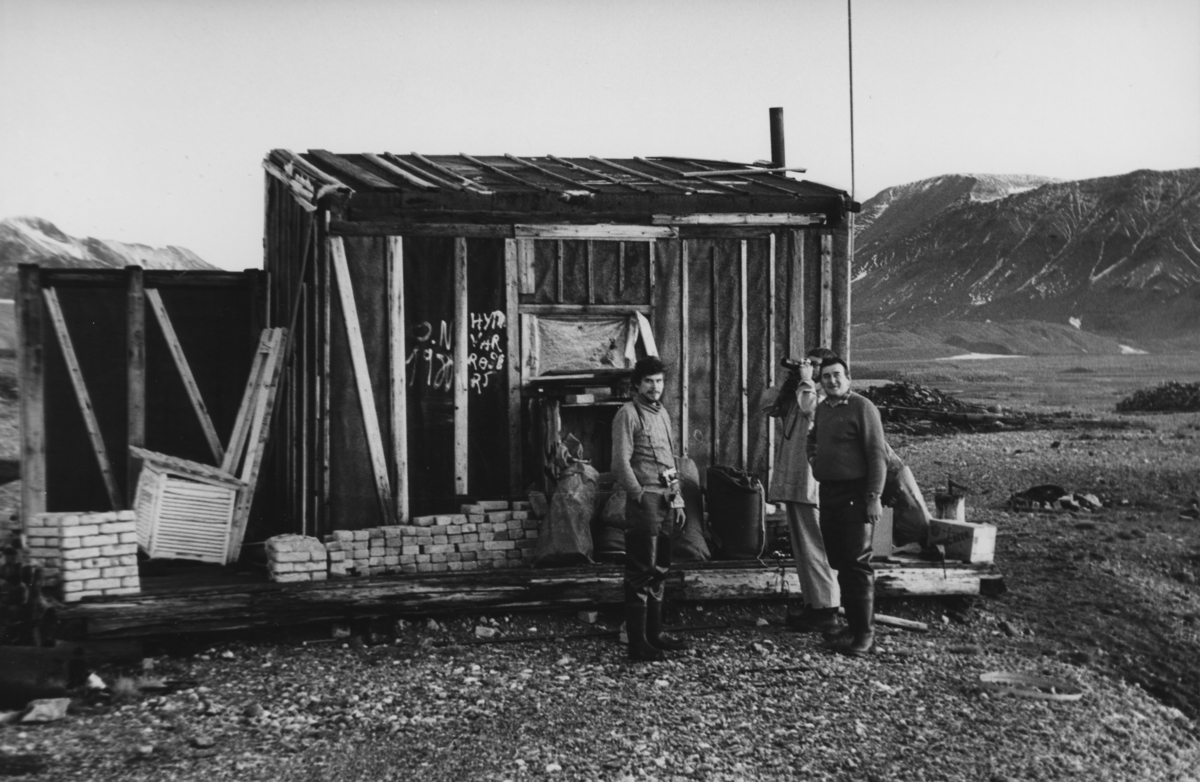 Forskere foran hytte i Gåshamna. Satt opp i 1965 på tufta etter Konstantinovka av Anders Opphaug og Asbjørn Voldset. ID: 138482