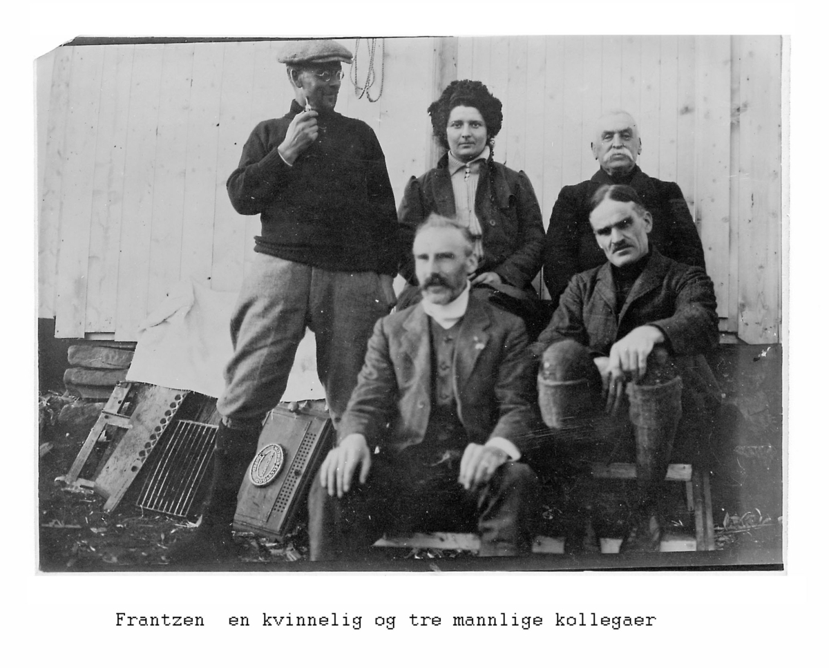 Alf Frantzens fotosamling: Fire menn og en kvinne foran Northern Exploration Company’s Camp Williamson på Barryneset ved Sveagruva. Alf Frantzen til venstre foran. 1912.
