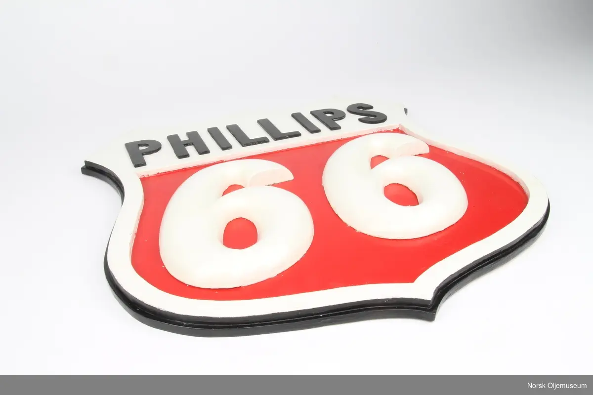 Skjoldformet skilt med relieffdekor. Skiltet ligner på Phillips sin logo.
