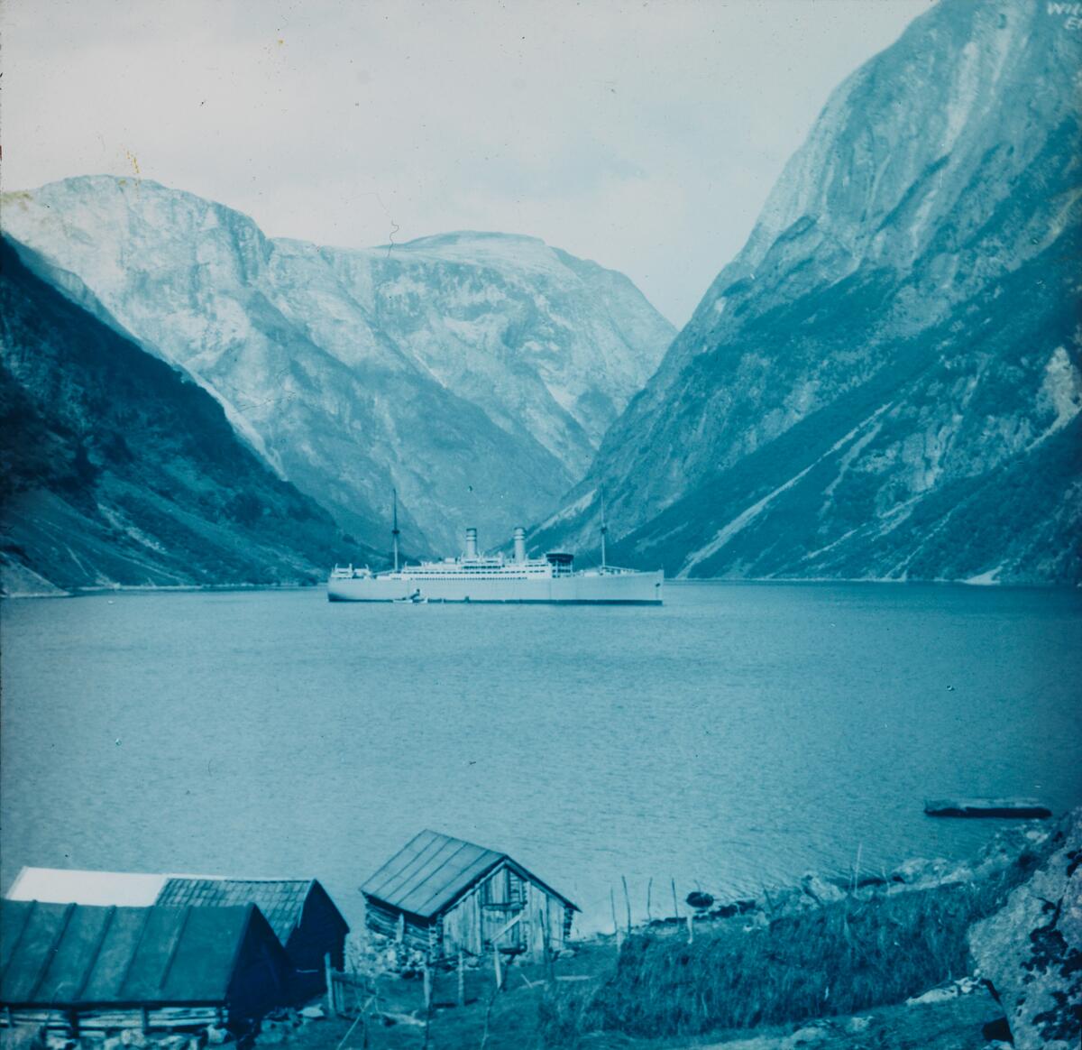 Dias. Et passasjerskip, "Stavangerfjord", ligger fortøyd i Nærøyfjorden. 