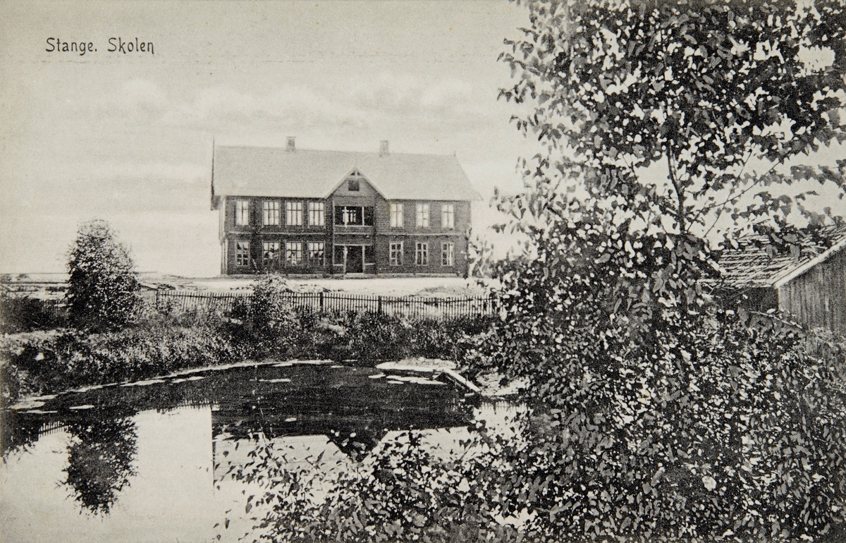 Postkort, Stange skole, Stange sentrum, Stangebyen, barneskole, 2 etasjes tømmerbygning bygd rundt 1910, damm i forgrunnen,