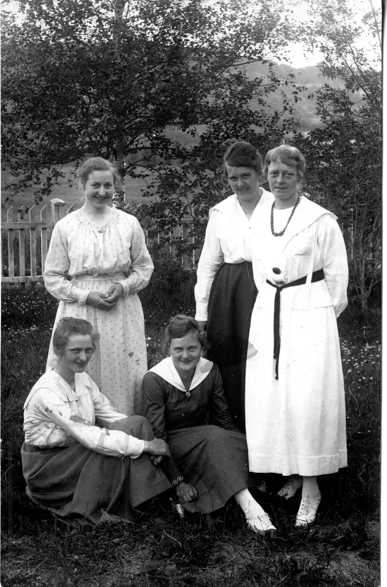 Fem kvinner samlet ute i en hage. Elever på husmorskole.
