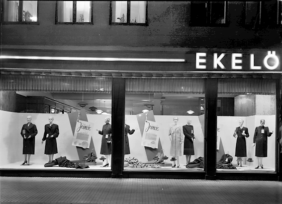 Exteriör av Ekelöf & Svensson. Skyltfönster med skyltdockor i.
1872 etablerade fröknarna Hilda Ekelöf och Carolina Svensson en detaljaffär i manufaktur. Vacklande hälsa gjorde att firman 1897  överläts till Wilh. Welin som skapade nya avdelningar, till exempel flaggtillverkningen (1900) och en syatelje för klänningar (1905) samt en modeaffär (1914) där bland annat Josefin Baker gick modell.  Sommaren 1999 lades verksamheten ner på grund av olönsamhet.
Källa: Nyblom-Svanqvist, Näringsliv i Värmland, 1945 och Värmlands Folkblad.