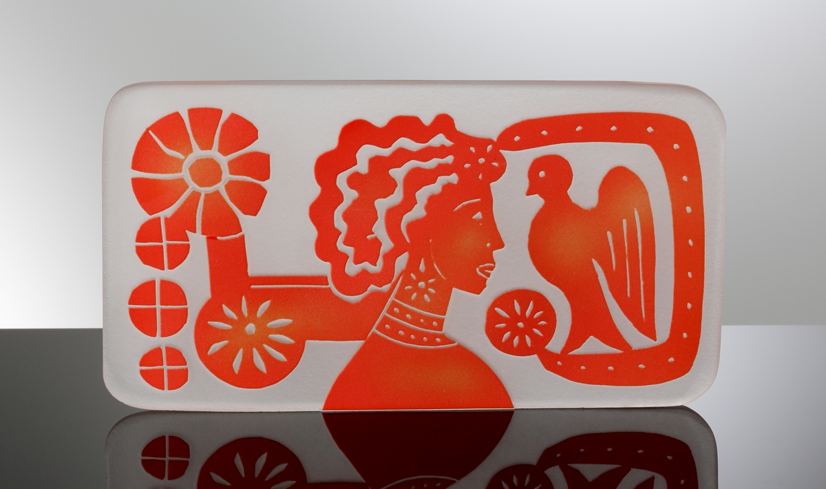 Formgiven av Edvin Öhrström. Platta med blästrad dekor av ”Flickan och Duvan” i röd färg. Troligen tänkt att ingjutas i ett glasblock.