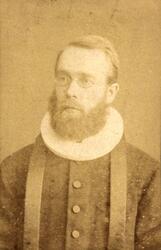 Portrett av en mann med skjegg, Presten Mowinkel, i preste- 