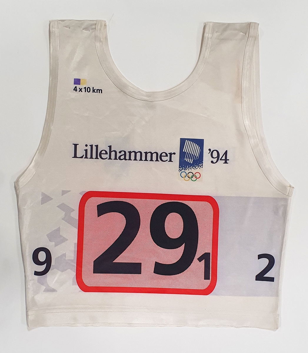 Hvitt startnummer utøver med nummer 29 - 1. Tallet er plassert i en rød firkant. Krystallmønster og emblem fra vinter-OL på Lillehammer 1994.