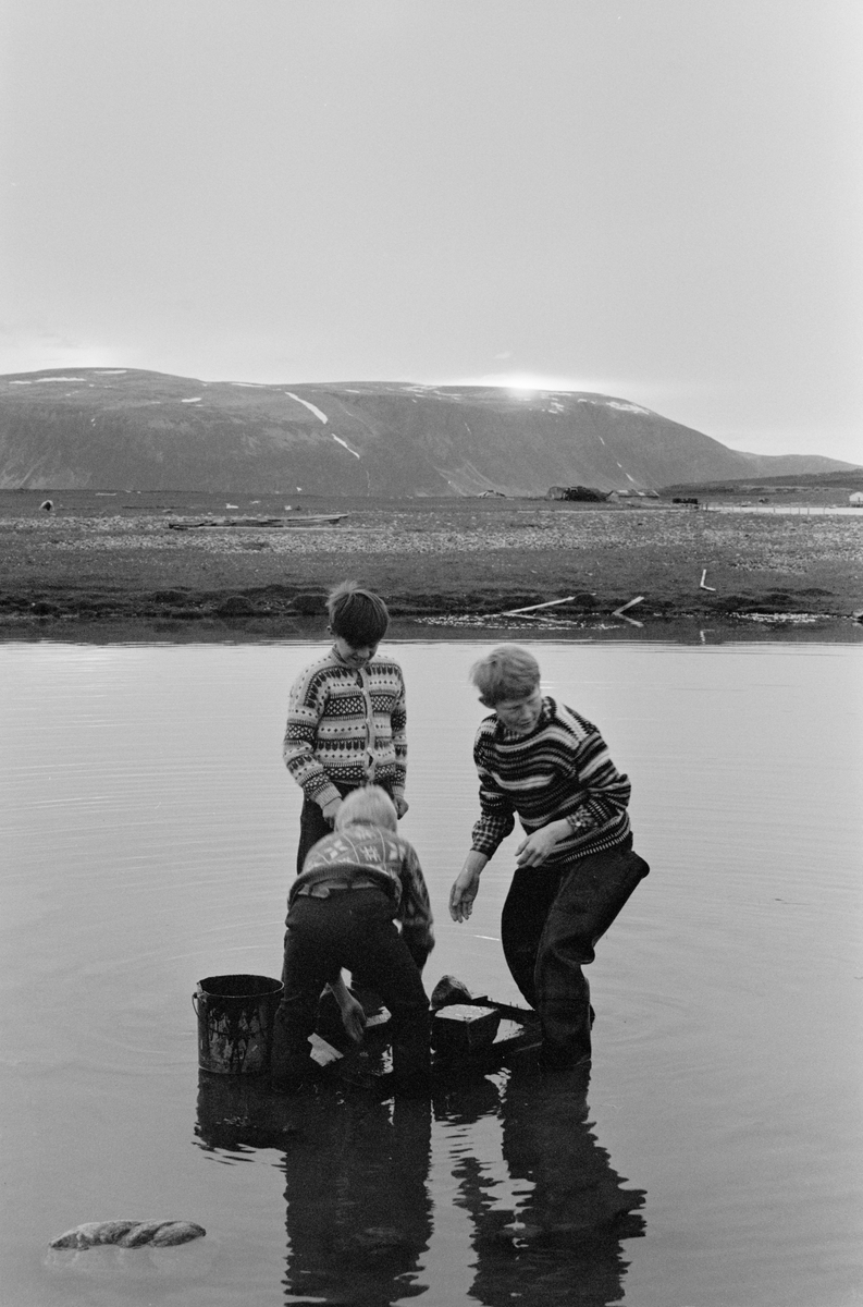 Tre gutter engasjert i ukjent aktivitet til knes i vannet.