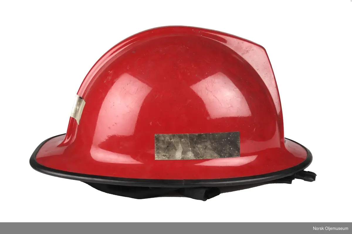Rød brannhjelm med reflekser på sidene og bak. Hjelmen er fra Shell-raffineriet på Sola i Rogaland.