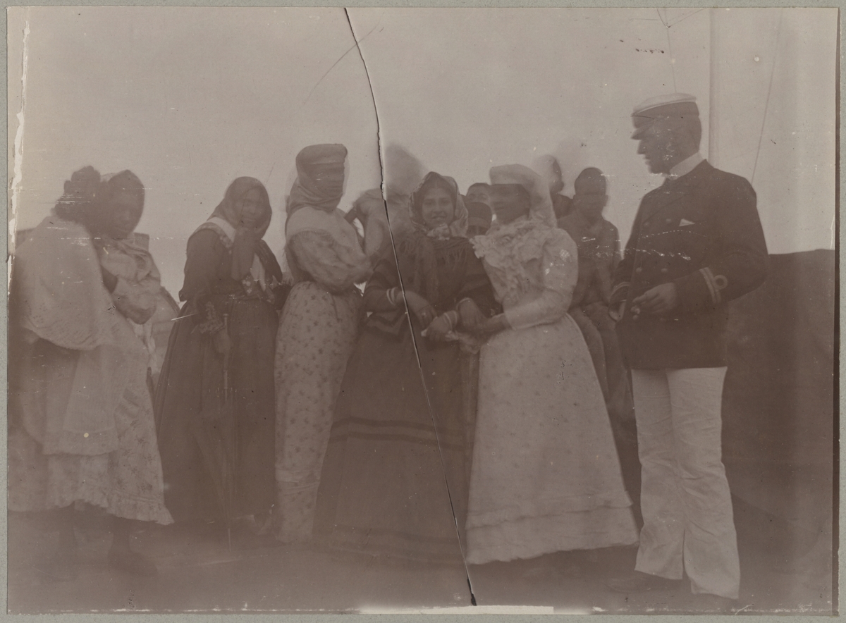 En grupp kvinnor i traditionella kläder vistas ombord på Balder. En av befälen tittar intresserat på de.