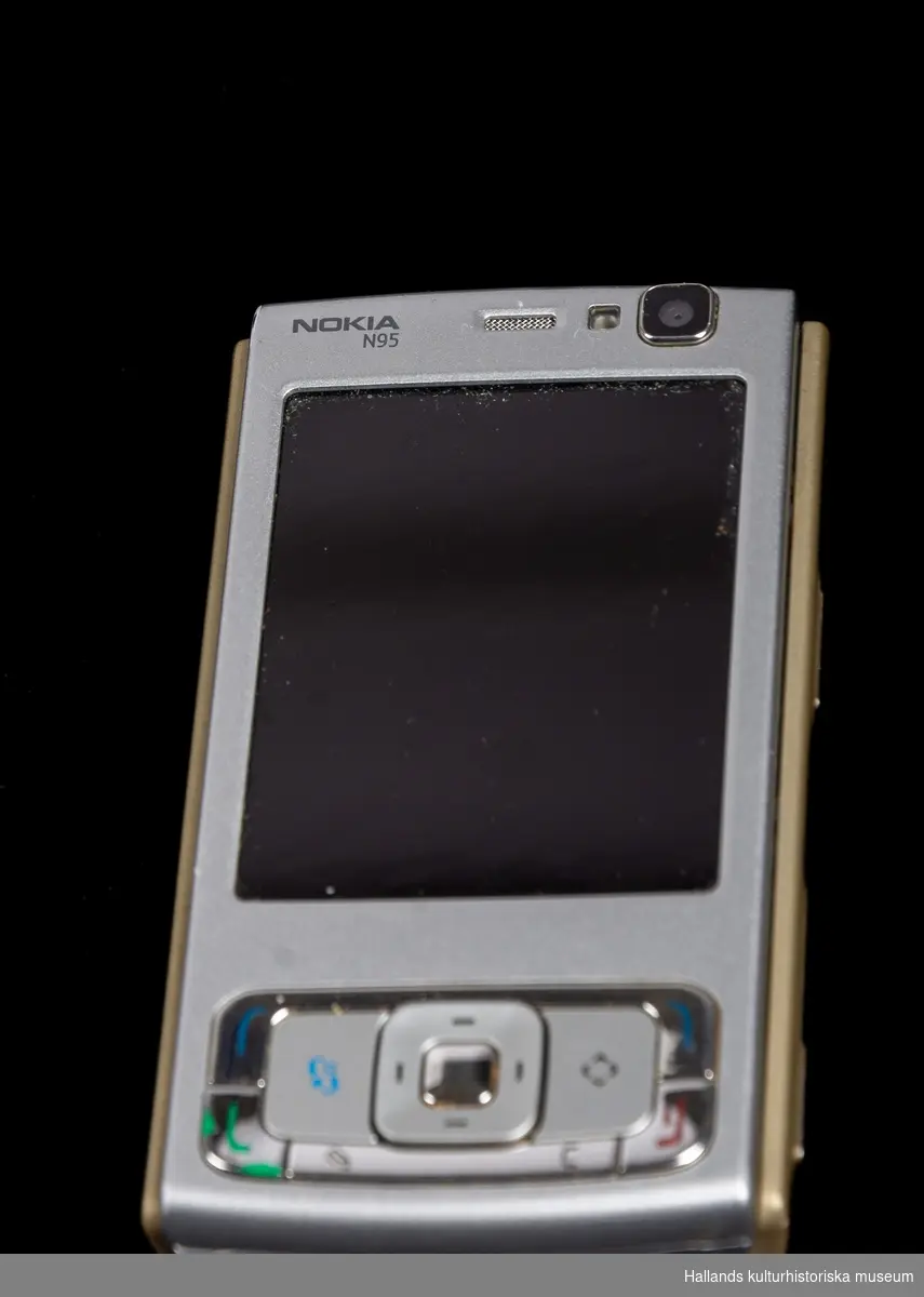 Nokia N95 (Tillverkare: Nokia, modell: N95) med yttre skal av hårdplast i grå- och guldmetallic.

På telefonens framsida en digital skärm, kameraoptik, en knappsats, samt märkningen: "Nokia n95". Hela framsidan är en skjutlucka som ger åtkomst till en knappsats undertill. På telefonens sidor finns en rad knappar, uttag samt en lucka för minneskort (i luckan sitter ett minneskort med kapacitet på 2gb). På telefonens baksida kameraoptik försedd med stängbar lucka samt en avtagbar lucka som döljer batteri och plats för telefonkort (sim). Luckan är märkt "Nokia".