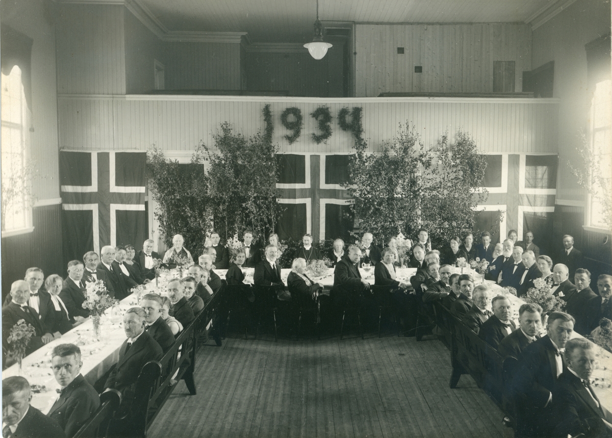 Forsamling rundt et festbord i Sangerhuset på Røros i 1934 i anledning Røros kirkes 150-årsjubileum.