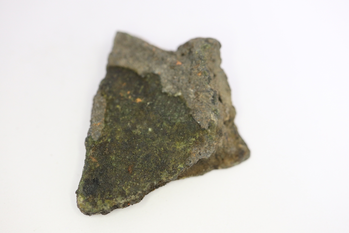 Brandskadat fragment av bronsgryta. Bukbit med eventuell skuldra.