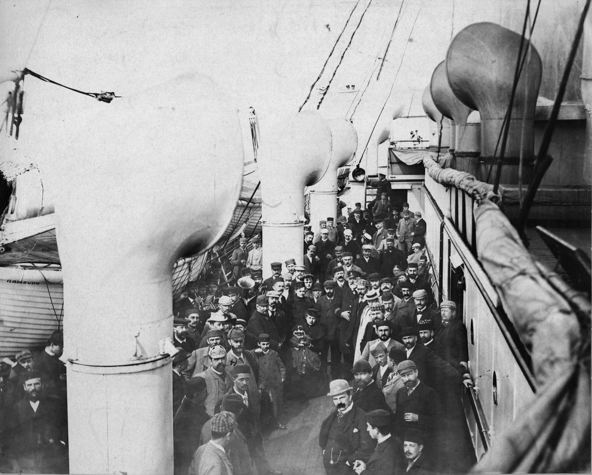 Passagerare på båt. Mannen med krysset över huvudet är R.W. Strehlenert. Troligen på 1880-talet.