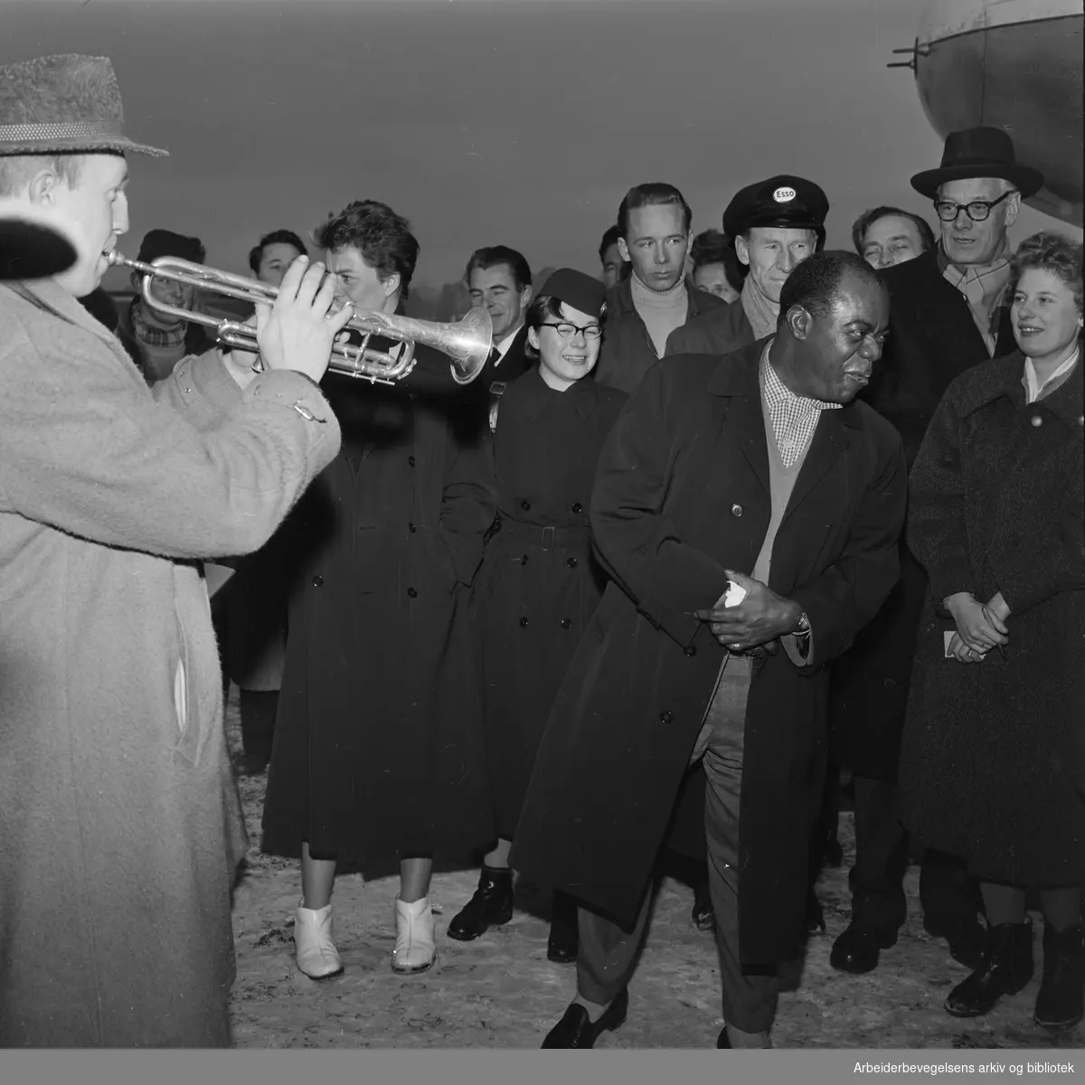 Louis Armstrong ankommer Oslo via Fornebu flyplass 2 februar 1959. Big Chief Jazzband og Eivind Solberg (tv) spiller.