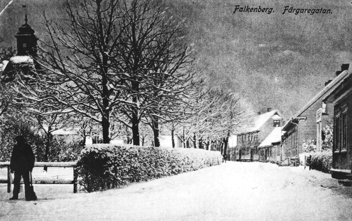 Vykort, "Falkenberg. Färgaregatan" i snöskrud. Till vänster ses tornet till S:t Laurentii kyrka. År 1919 byttes gatunamnet till Nicolaigränd och 1921 fick gatan sitt nuvarande namn: S:t Lars Kyrkogata.