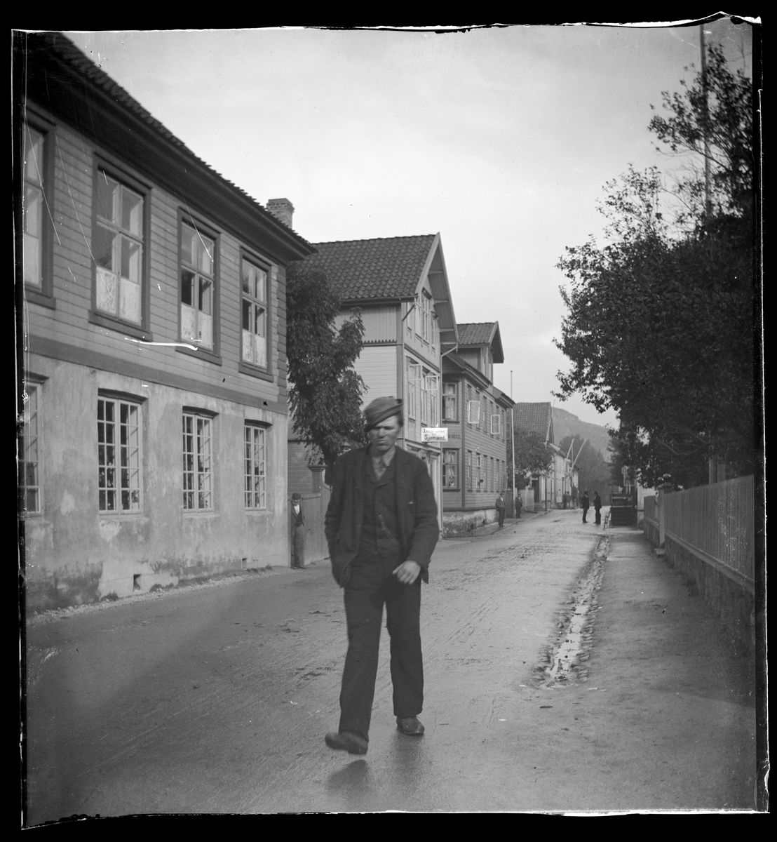 Mann spaserer i Strandgaten i Egersund ved nr. 58 og parken