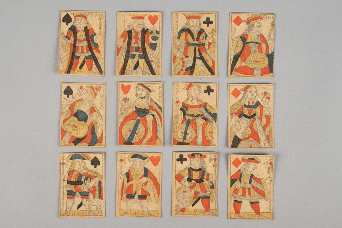 34 spillekort av fransk type, Paris-standard, med spisse hjørner. Produsert i Danmark-Norge. Figurkortene er ikke speilet. Produsentene har merket kløver knekt med sine egne navn.