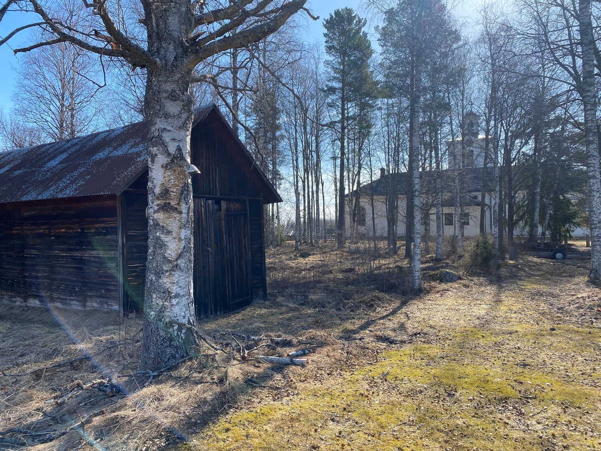Vy från markyta dit det gamla bostadshuset från gården Granänge ska flyttas, mot Skogs kyrka.