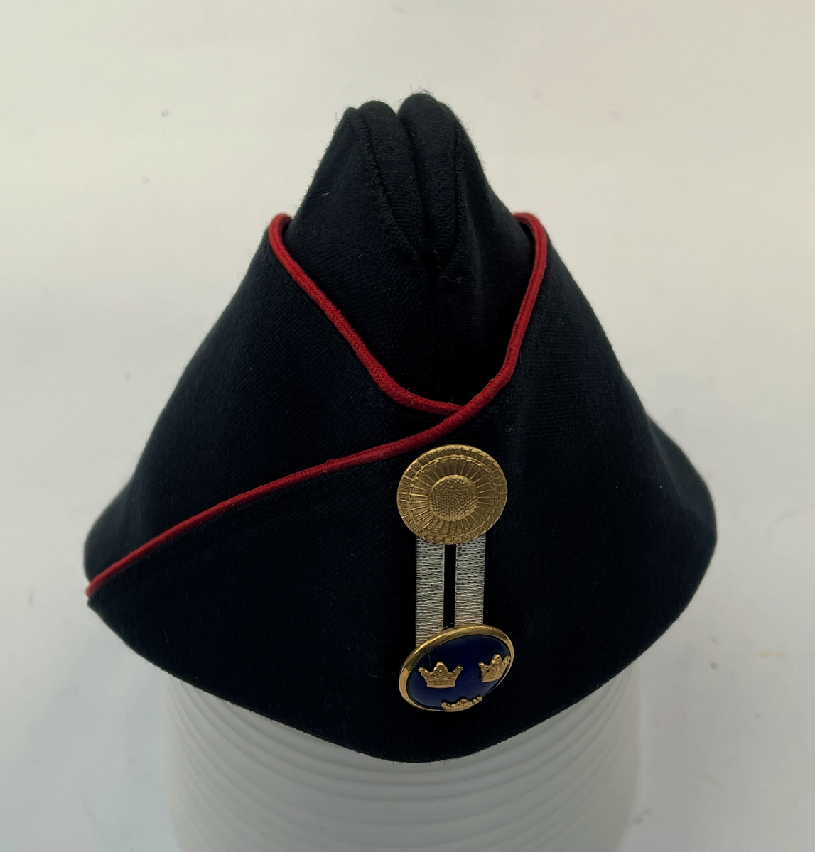Mörkblå Båtmössa m/1960 med röd passpoal. Agraff i silver.  Knapp för officer m/1865.
