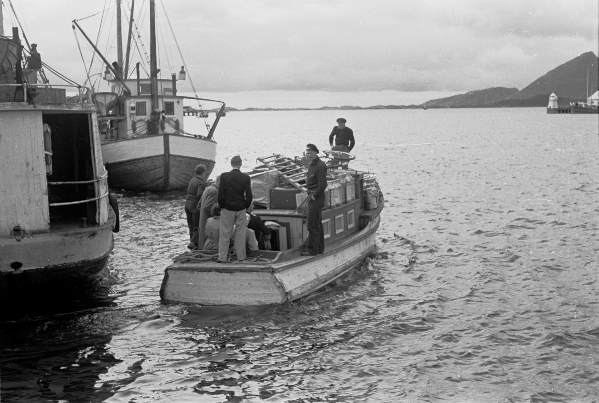 Alstahaug, Sandnessjøen. Båten "Vesla er ferdig lastet og er på vei ut fra kaia i Sandnessjøen, på vei til Leirfjord med gods og folk. Båten fraktet folk, gods, varer og melkespann mellom Sandnessjøen og Leirfjord.