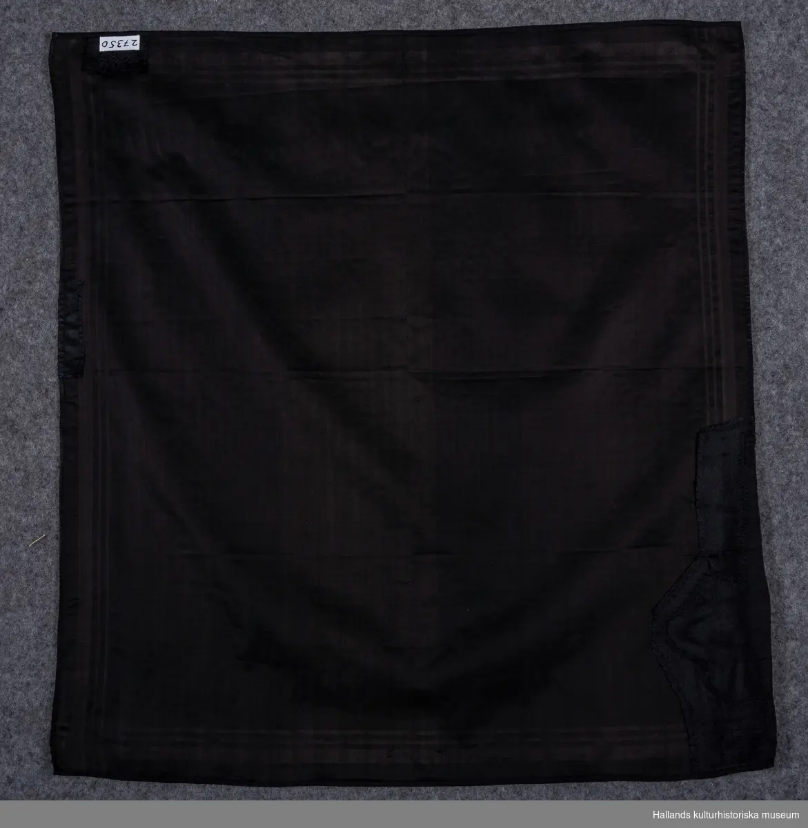 Huvudduk av svart siden med sammansatt bindning i kypertbotten och med satinränder i kanterna.