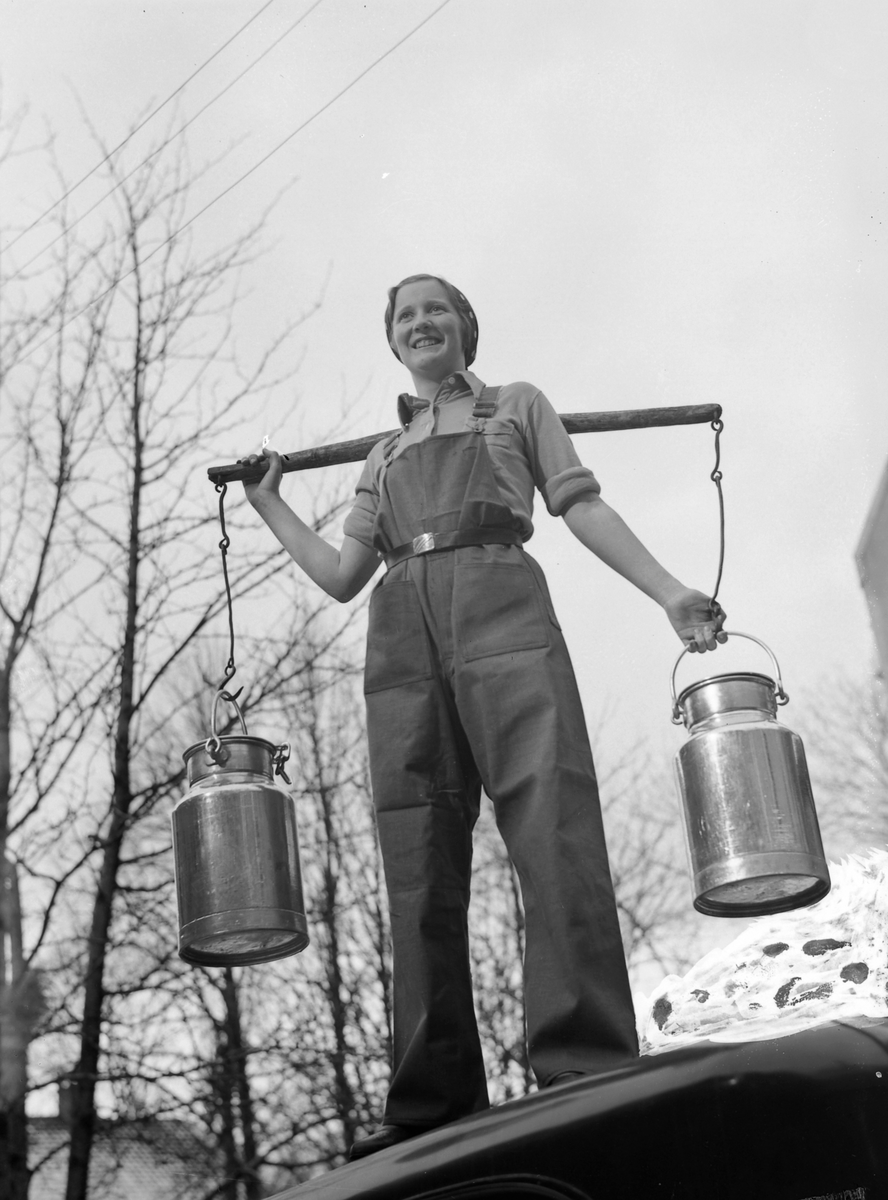 Kvinne bærer melkepann med vassåk