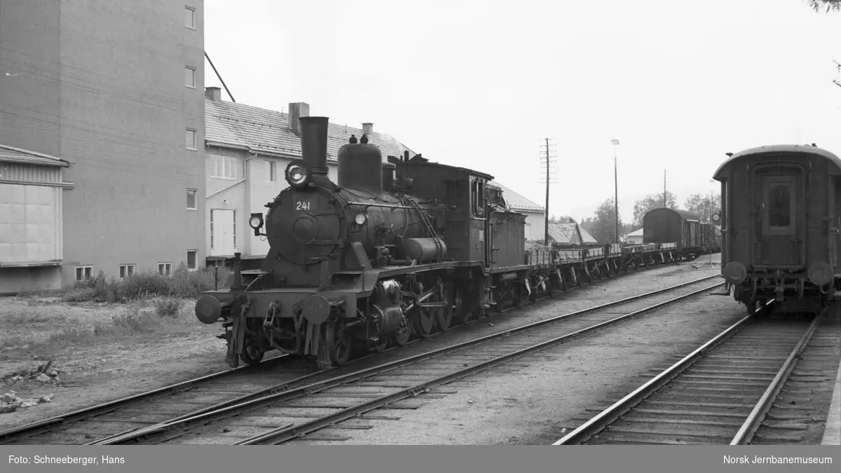 Damplokomotiv type 18c nr. 241 med godstog på Koppang stasjon. Til høyre bakerste vogn til dagtoget til Trondheim, tog 301
