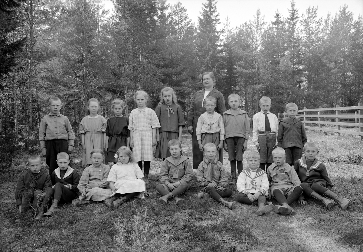 Lärarinnan Anna Isaksson med sina elever vid Lidens skola i Västra Harg. Året är 1925 och hon hade då undervisat och även bott i skolan sedan 1909.