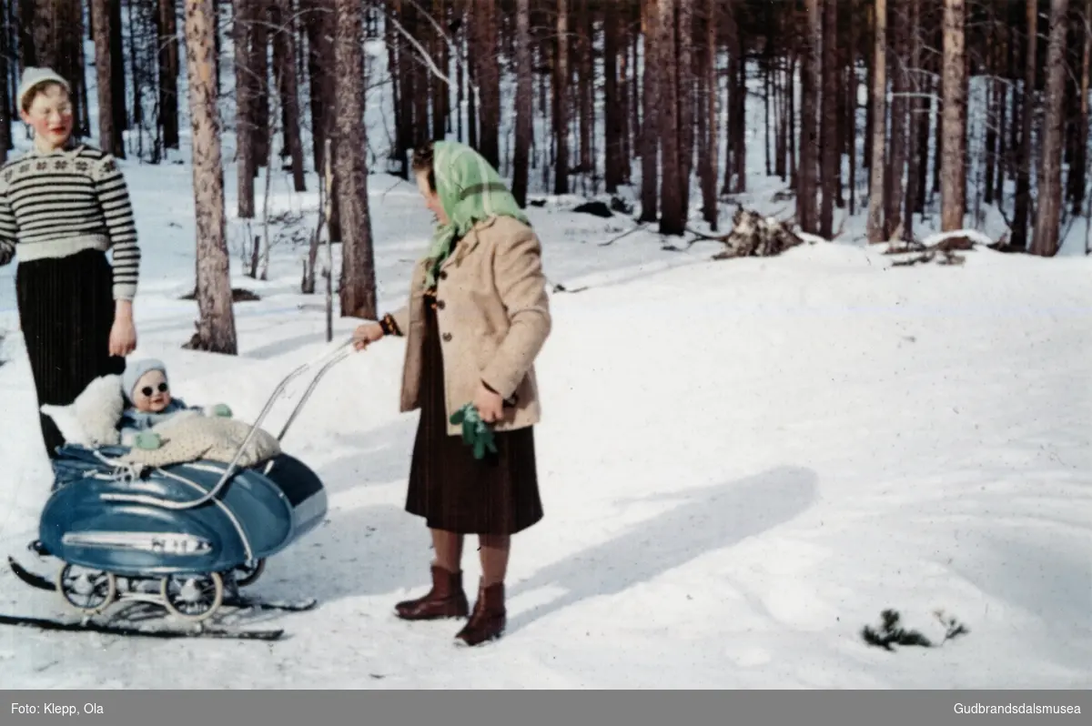 Malene Klepp (f. Dagsgard 1929) har fått ski under hjula på barnevogna til Håkon Klepp (f. 1957). Bak står Asbjørn Dagsgard (f. 1943)