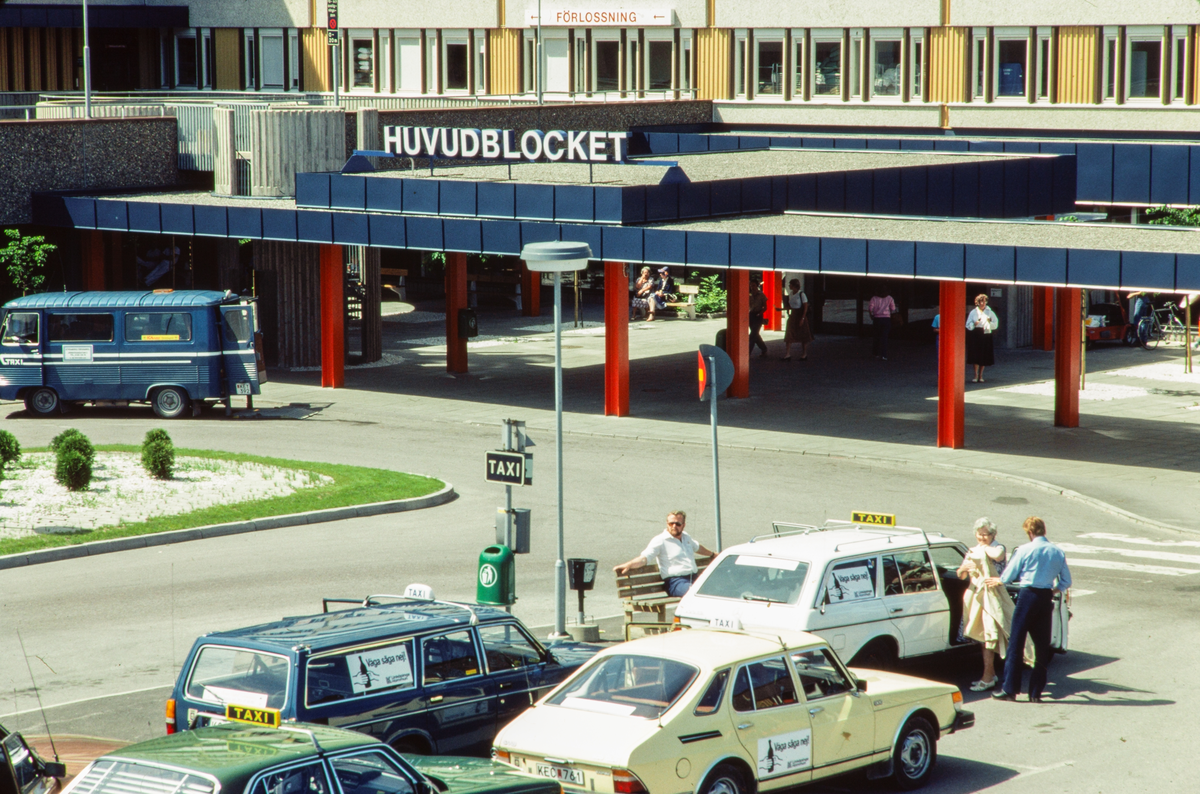 Entrén till Huvudblocket på Ril, Regionsjukhuset i Linköping. Utanför entrén ser man taxibilar samt en Saab. Taxiplats. Ovanför entrén till Huvudblocket låg förlossningen. Idag kallas sjukhuset Universitetssjukhuset i Linköping.

Bilder från staden Linköping digitaliserade från diapositiv. Bilderna är från 1970-1990-talet.